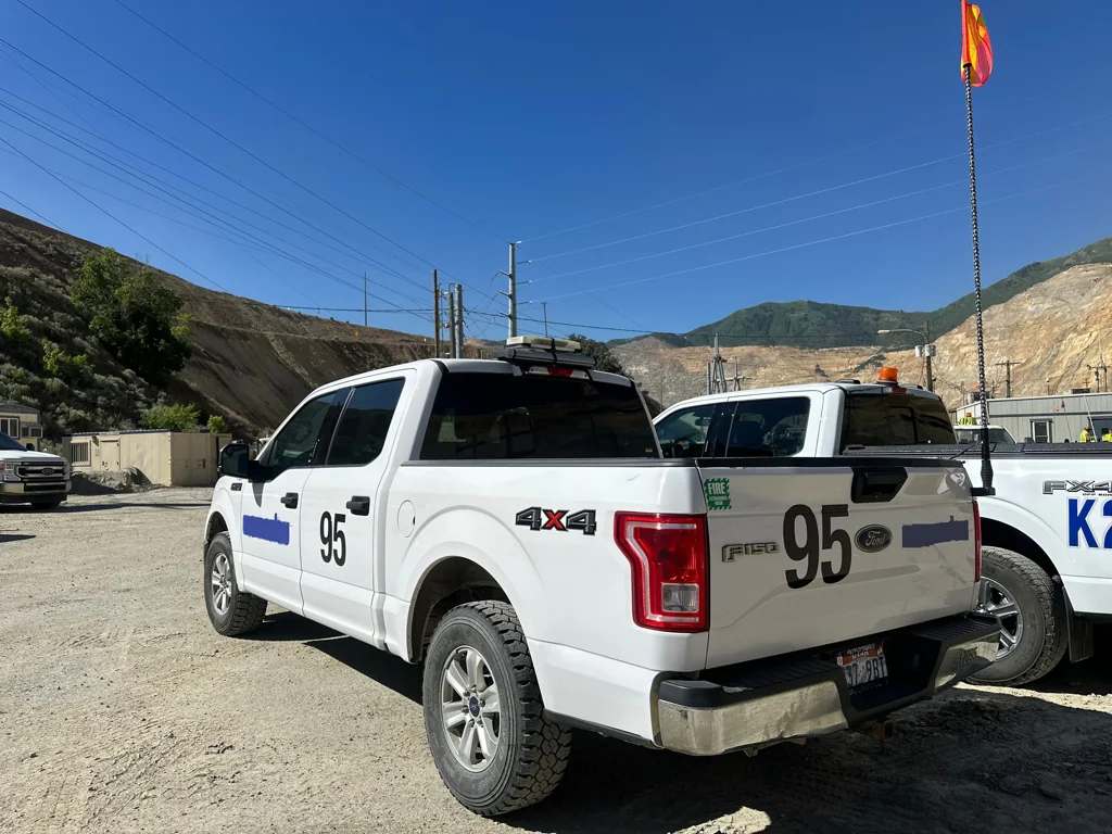White commercial pickup truck with a Gorilla Whips safety whip and orange flag